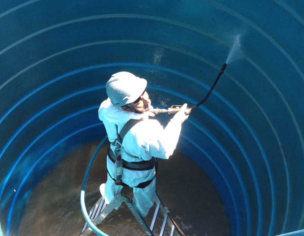Technician disinfecting inside a water storage tank
